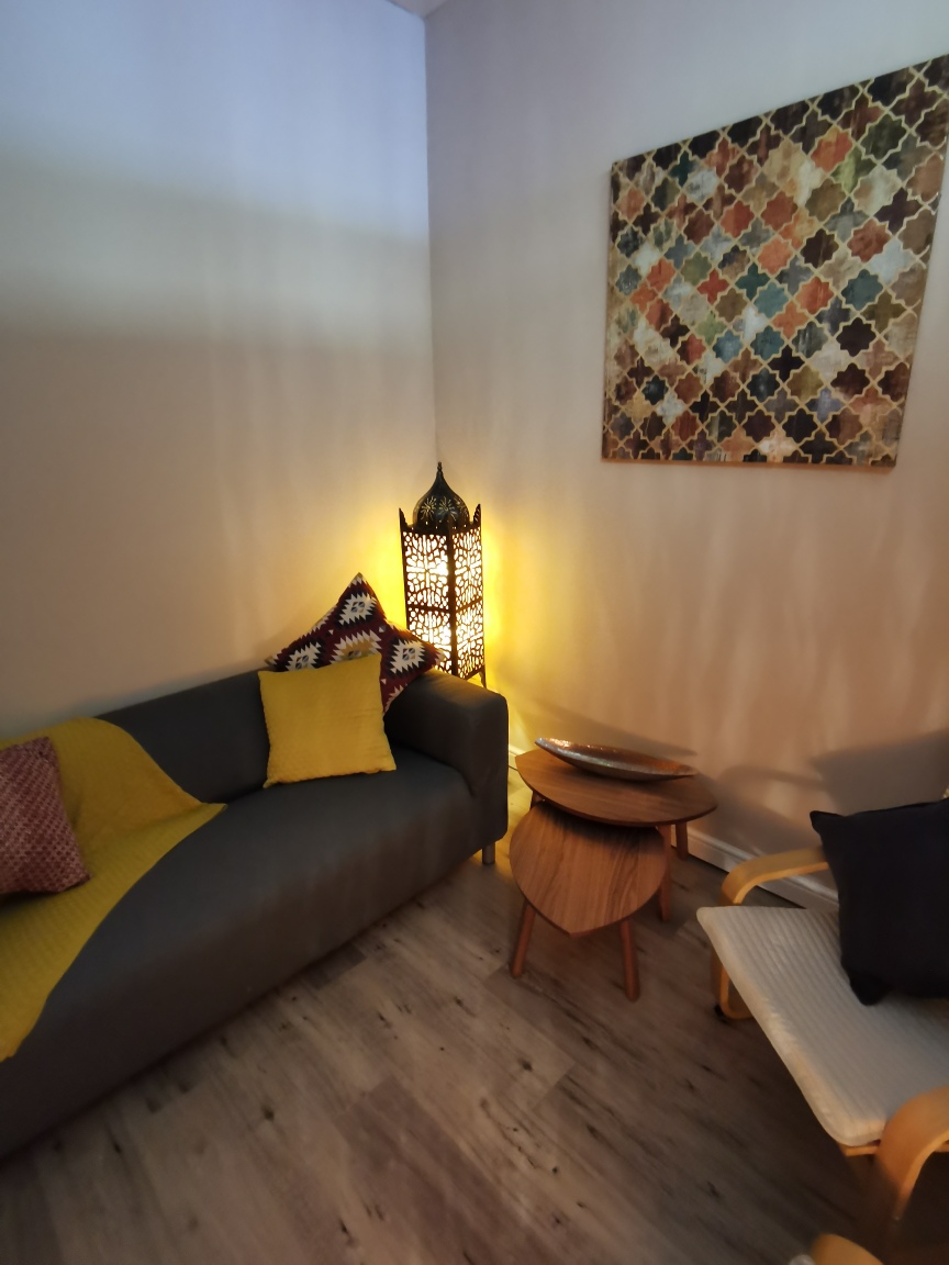 The relaxation room with a grey sofa, yellow cushions and a lantern lamp