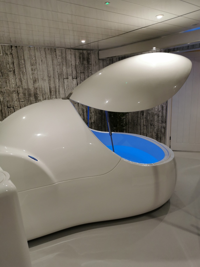 A float pod with its lid raised and the water lit blue